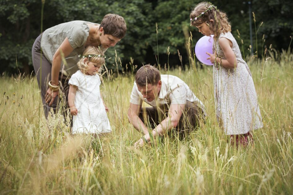 Family with two children playing in a meadow.